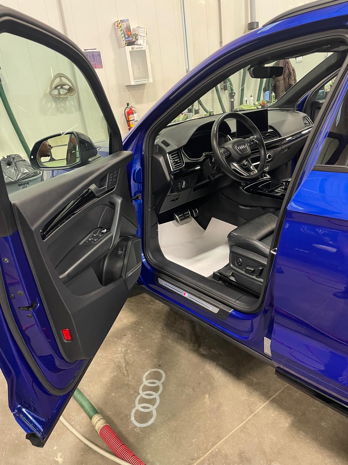 Clean luxury driver footwell, pedals, and illuminated door sill